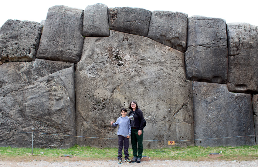 Mother and son in front of megalithic wall
