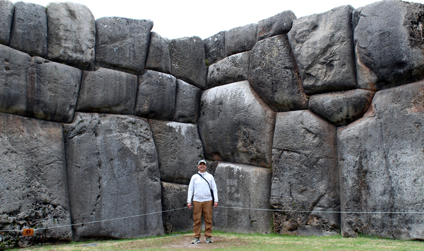 Man standing in front of megalithic wall