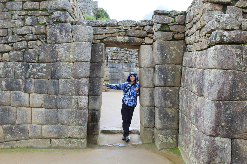 Youth standing in doorway of megalithic walls